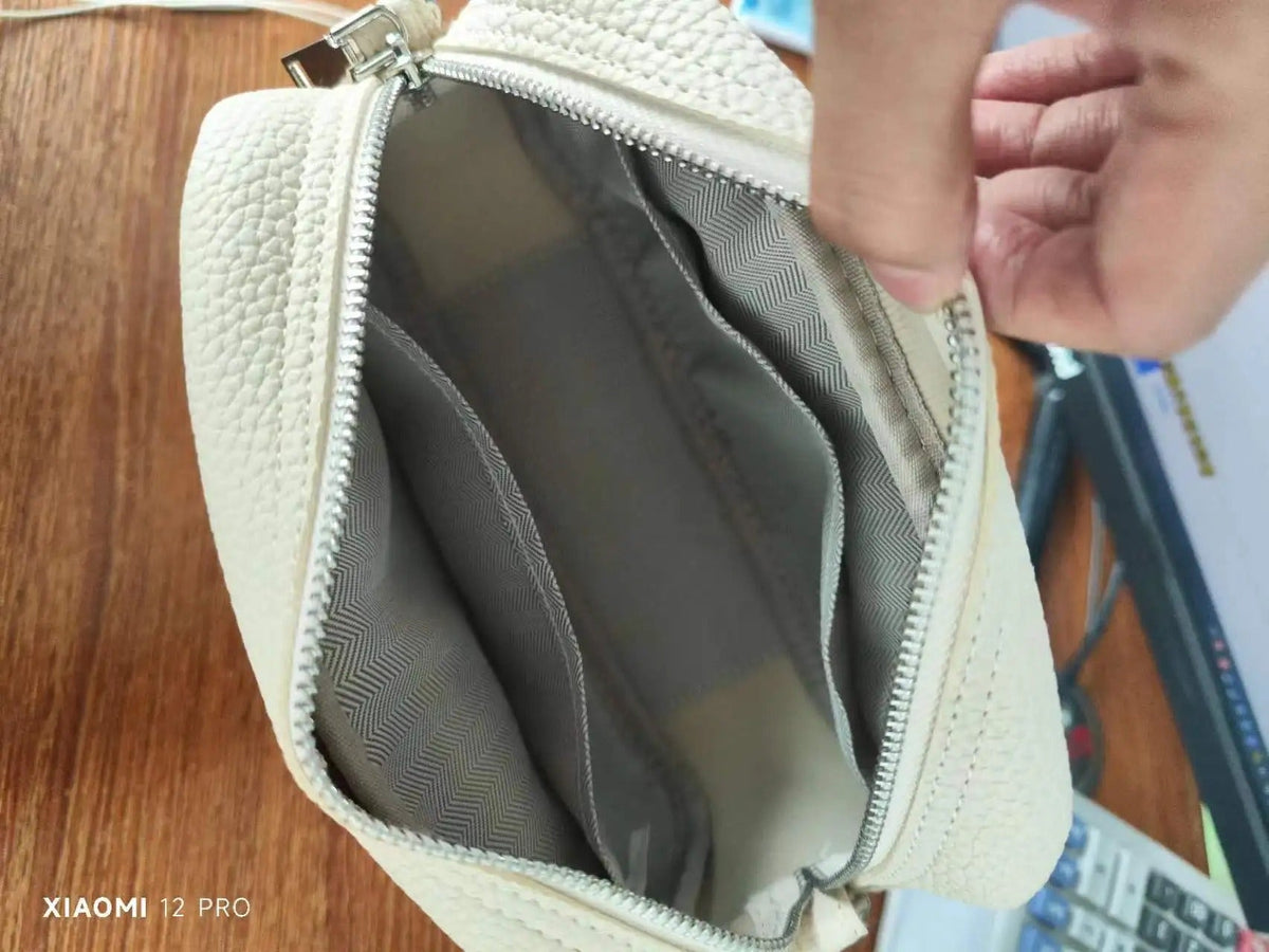 Bolso beige con textura, cremallera y forro gris, ideal para mujer, mostrando su interior organizado