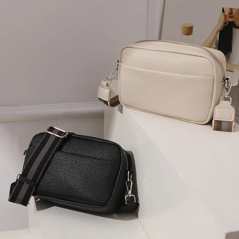 Bolso cruzado pequeño en negro y beige, textura granulada, correa ajustable, ideal para mujer