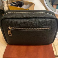 Bolso cosmético negro texturizado con cremallera dorada, ideal para maquillaje y viajes